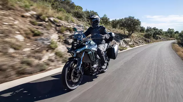 Suzuki V-Strom 800RE Tour riding along a mountain pass.