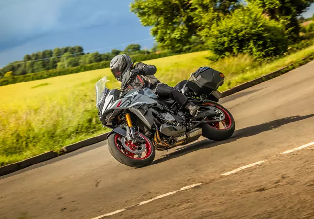 Suzuki GSX-S1000GX+ leaning into a corner on a country road