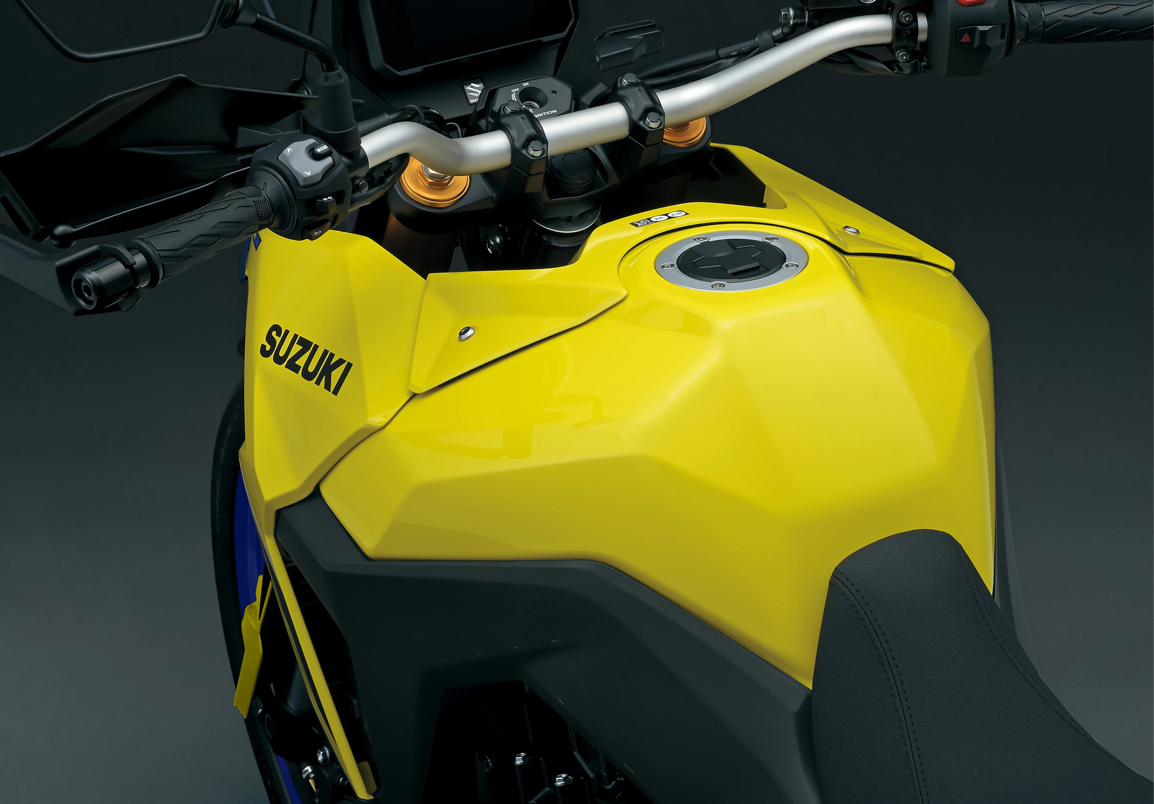 A close-up view of the Suzuki V-Strom 800DE’s yellow fuel tank and seat