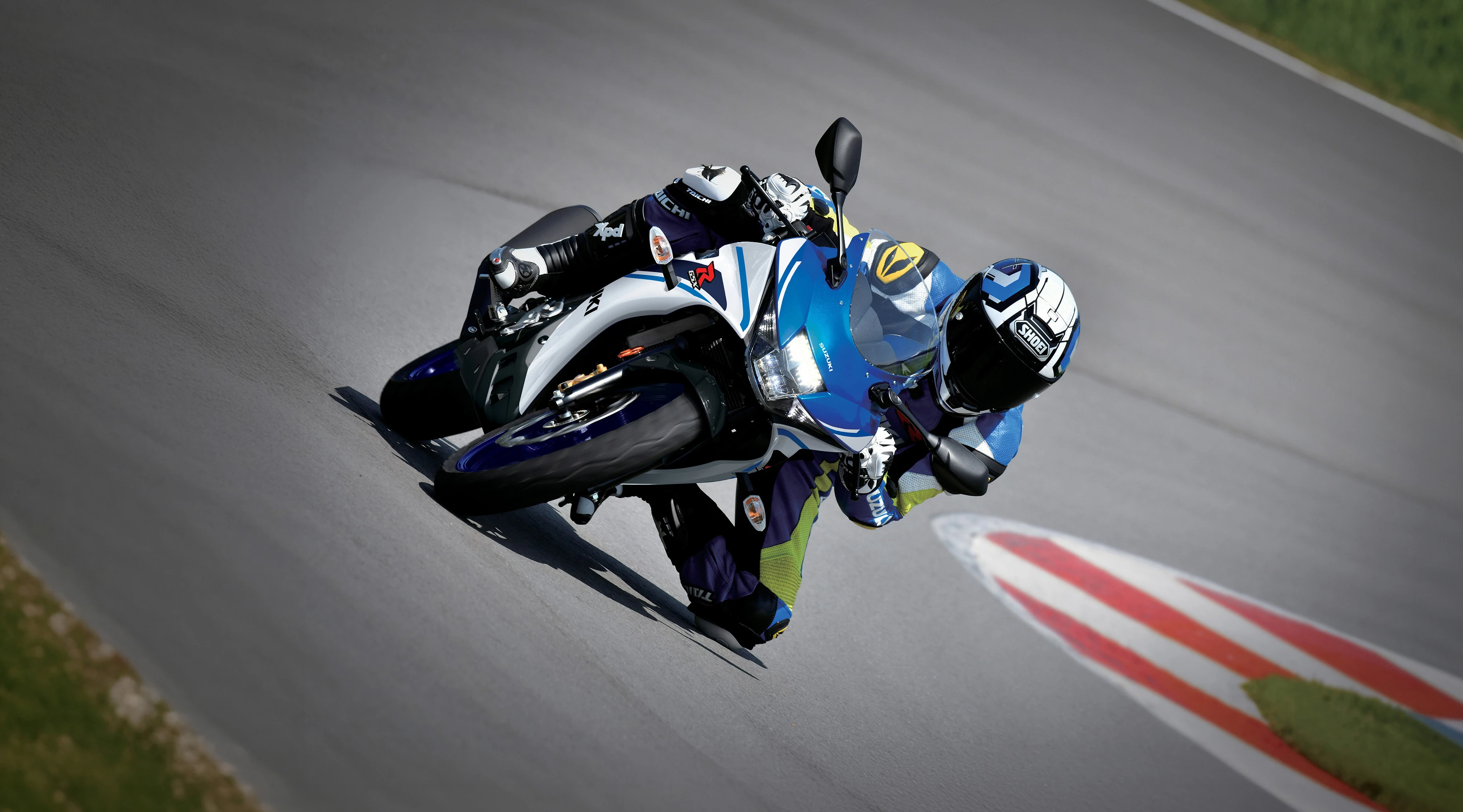 Suzuki GSX-R125 leaning hard into a corner out on track.