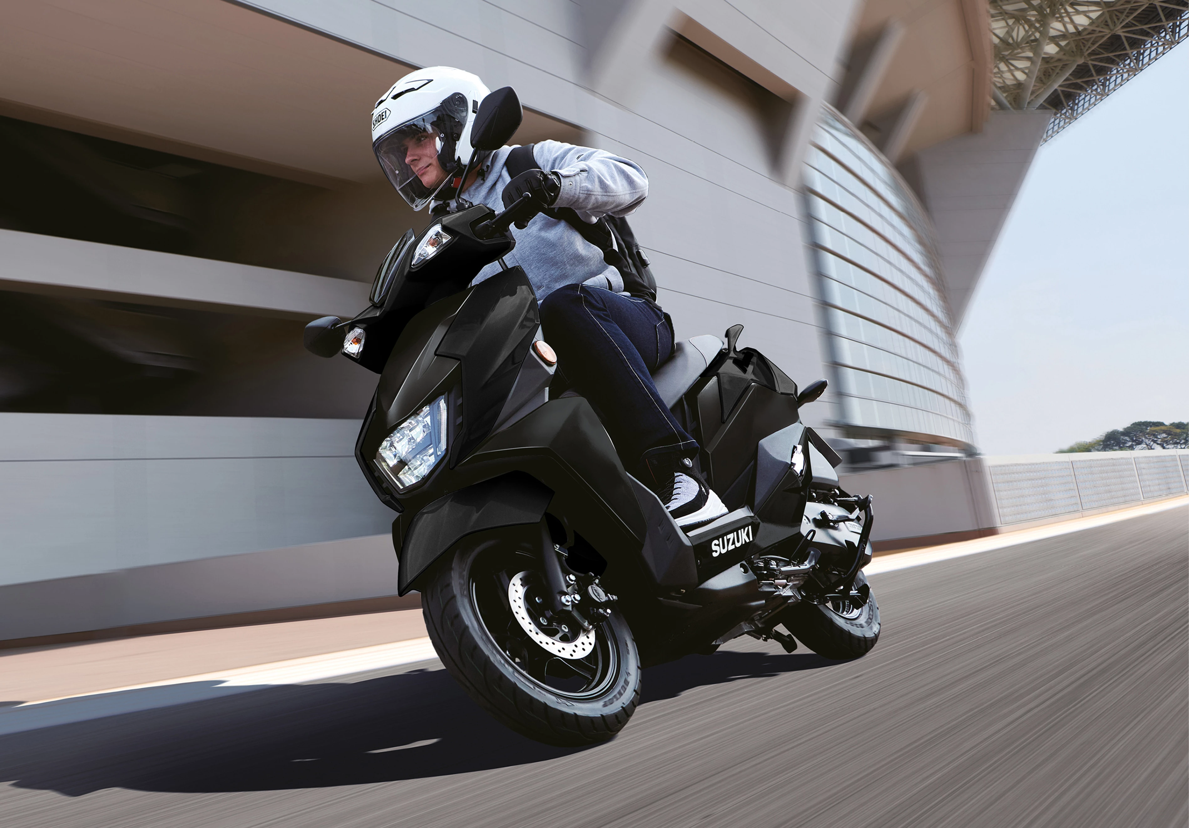 Suzuki Avenis 125 navigating city streets, showcasing its practicality and urban agility.