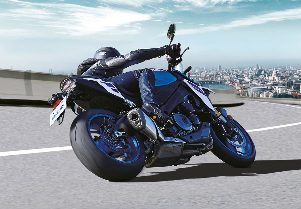 Suzuki GSX-S1000 leant over going around a corner outside a city landscape