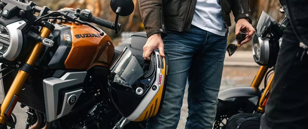 Suzuki GSX-8T right hand side tank static with rider holding helmet next to the bike
