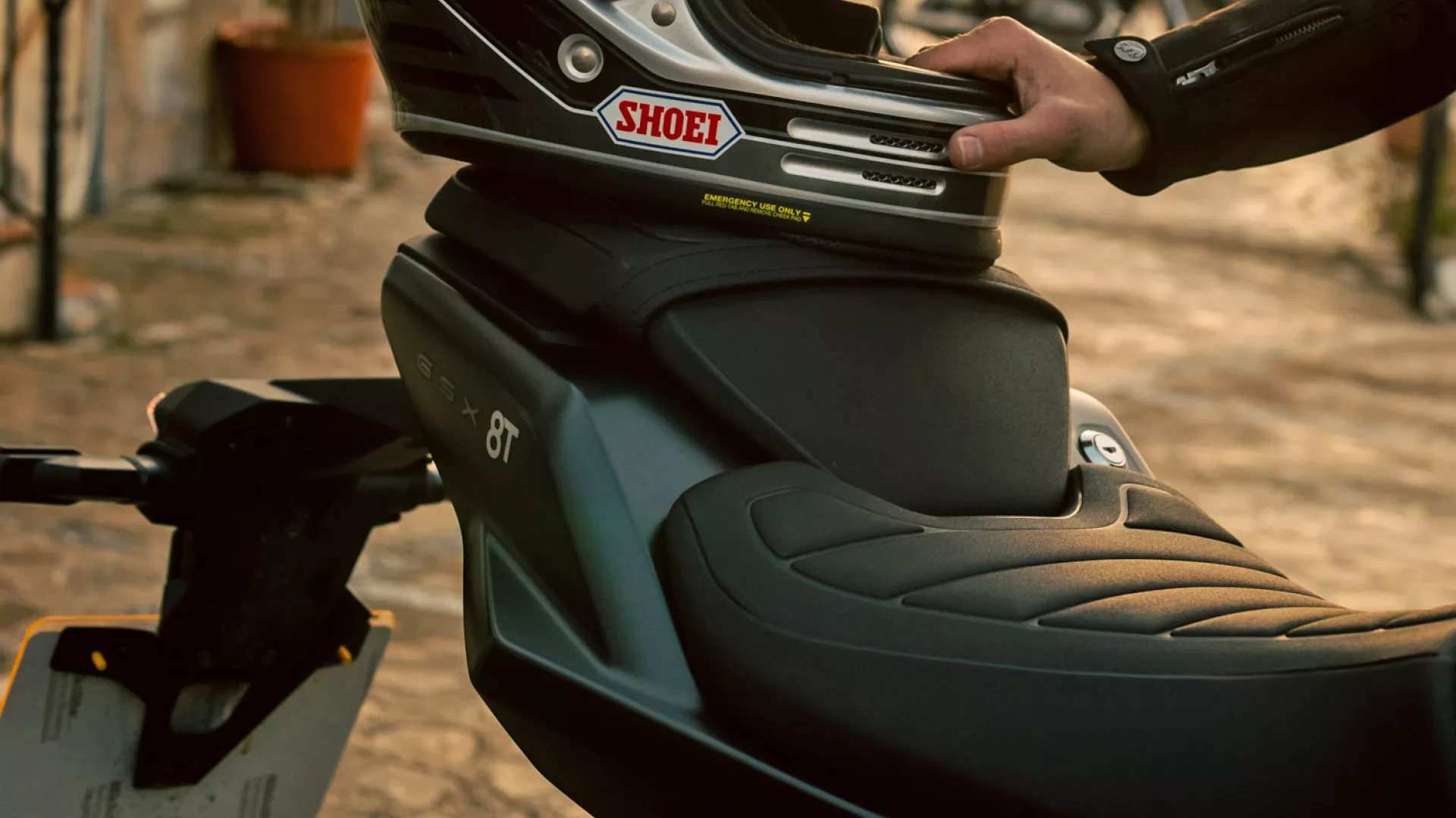 Suzuki GSX-8T rear seat with rider placing helmet on pillion seat on location