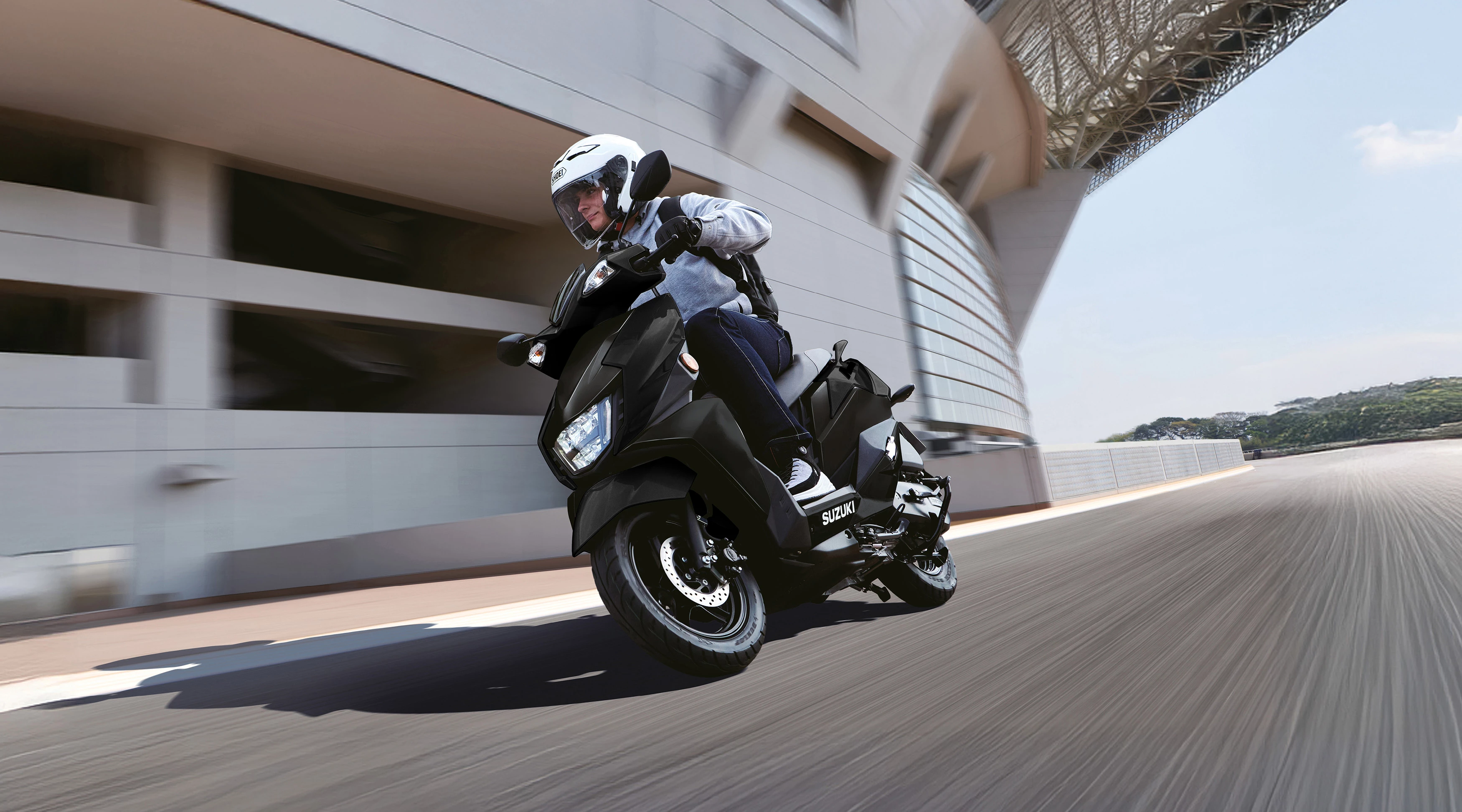 Angled view of the Suzuki Avenis scooter in an urban setting, showcasing its contemporary design.