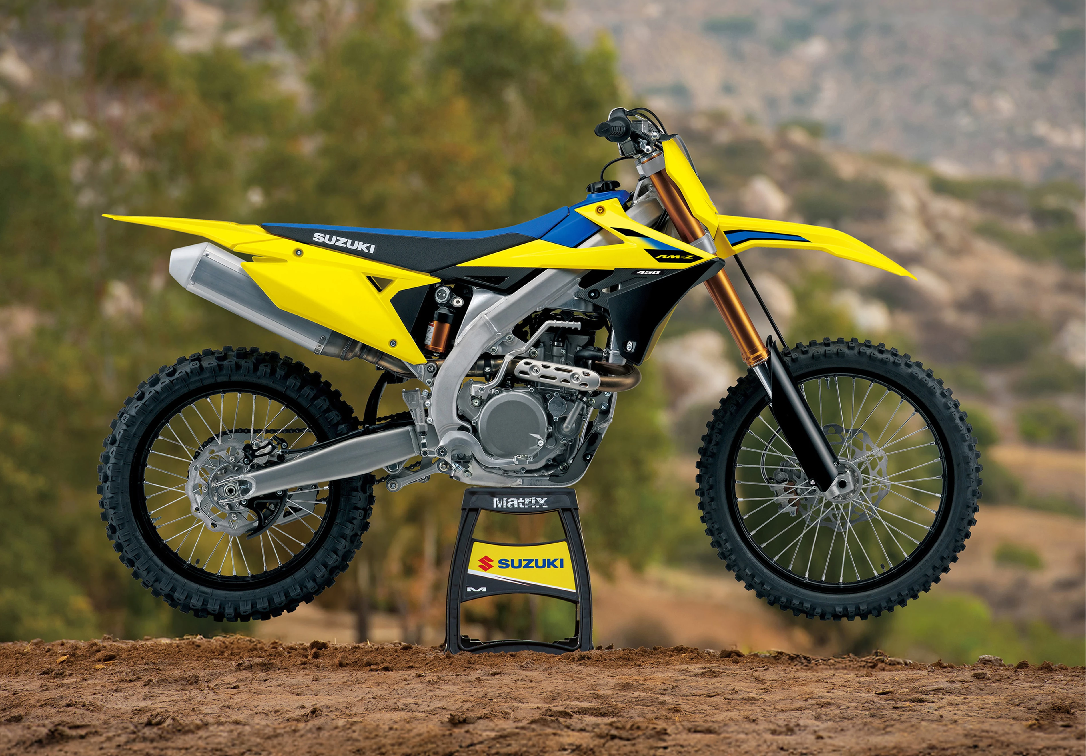 Suzuki RM-Z450 on a stand with mountains in the background