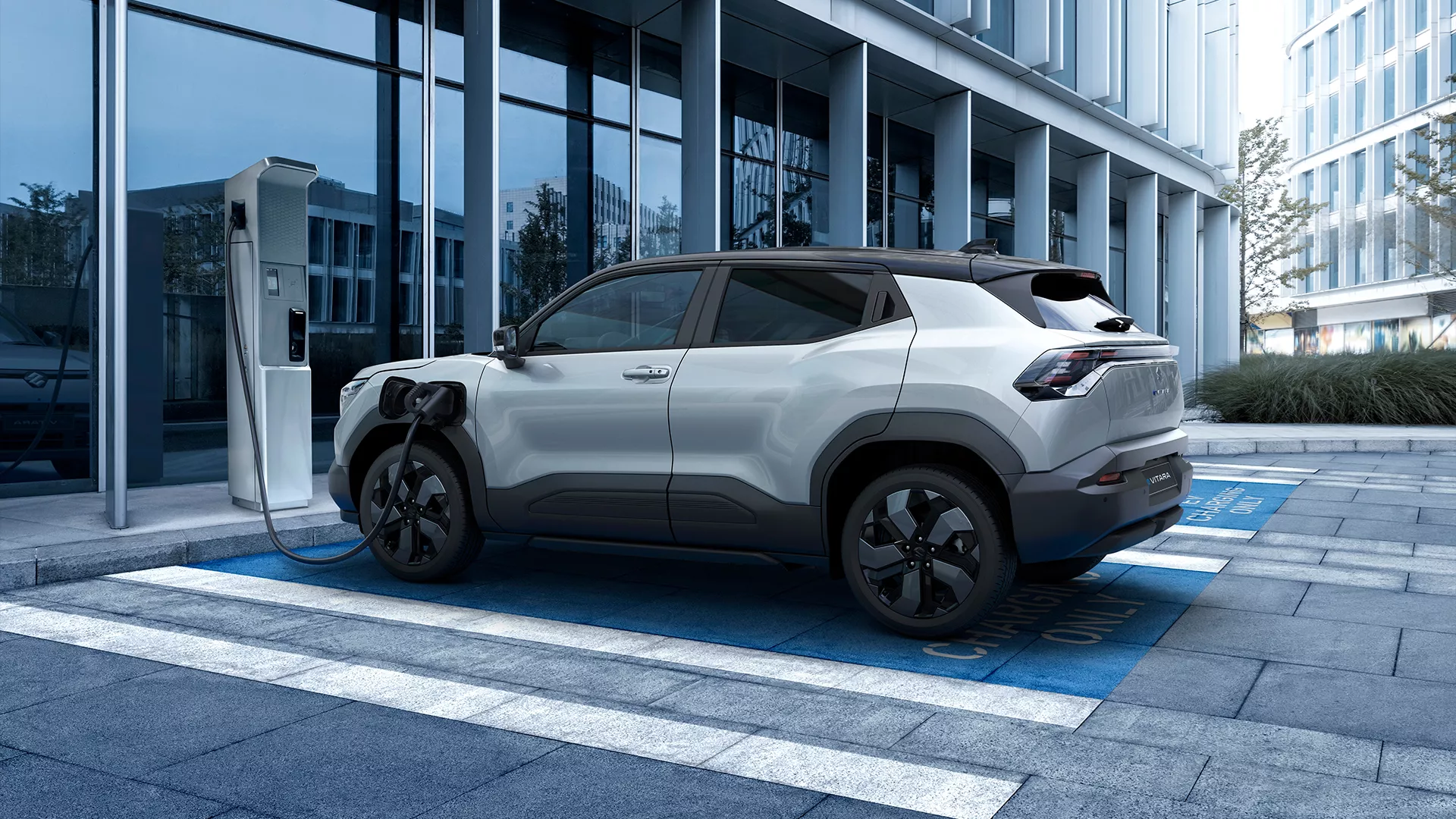 Suzuki e Vitara charging at a public station, showcasing front and rear parking sensors