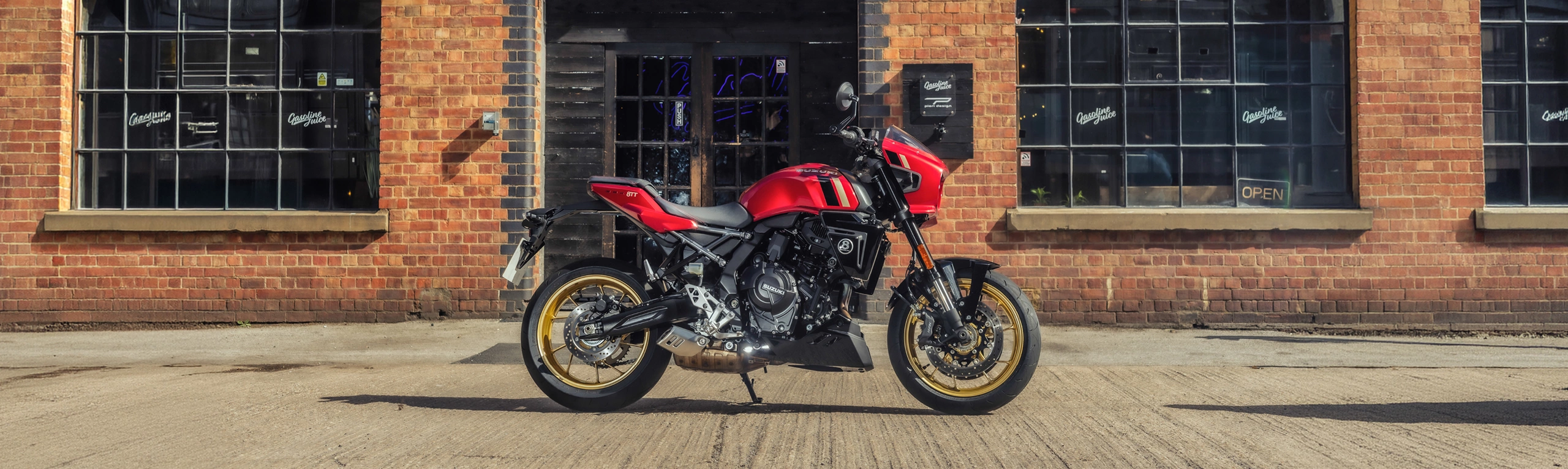 Suzuki GSX-8TT red, static right hand side in front of an old brick industrial building