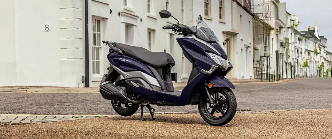 Suzuki Burgman Street 125EX static with a village background