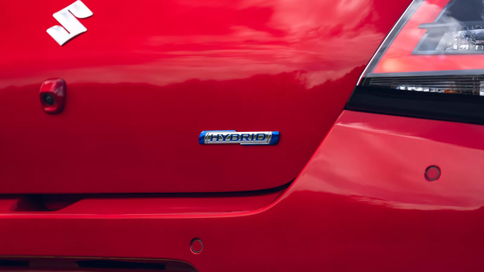 Close-up of the Suzuki swift rear tailgate showing the Hybrid badge beneath the tail light, highlighting its electrified drivetrain.