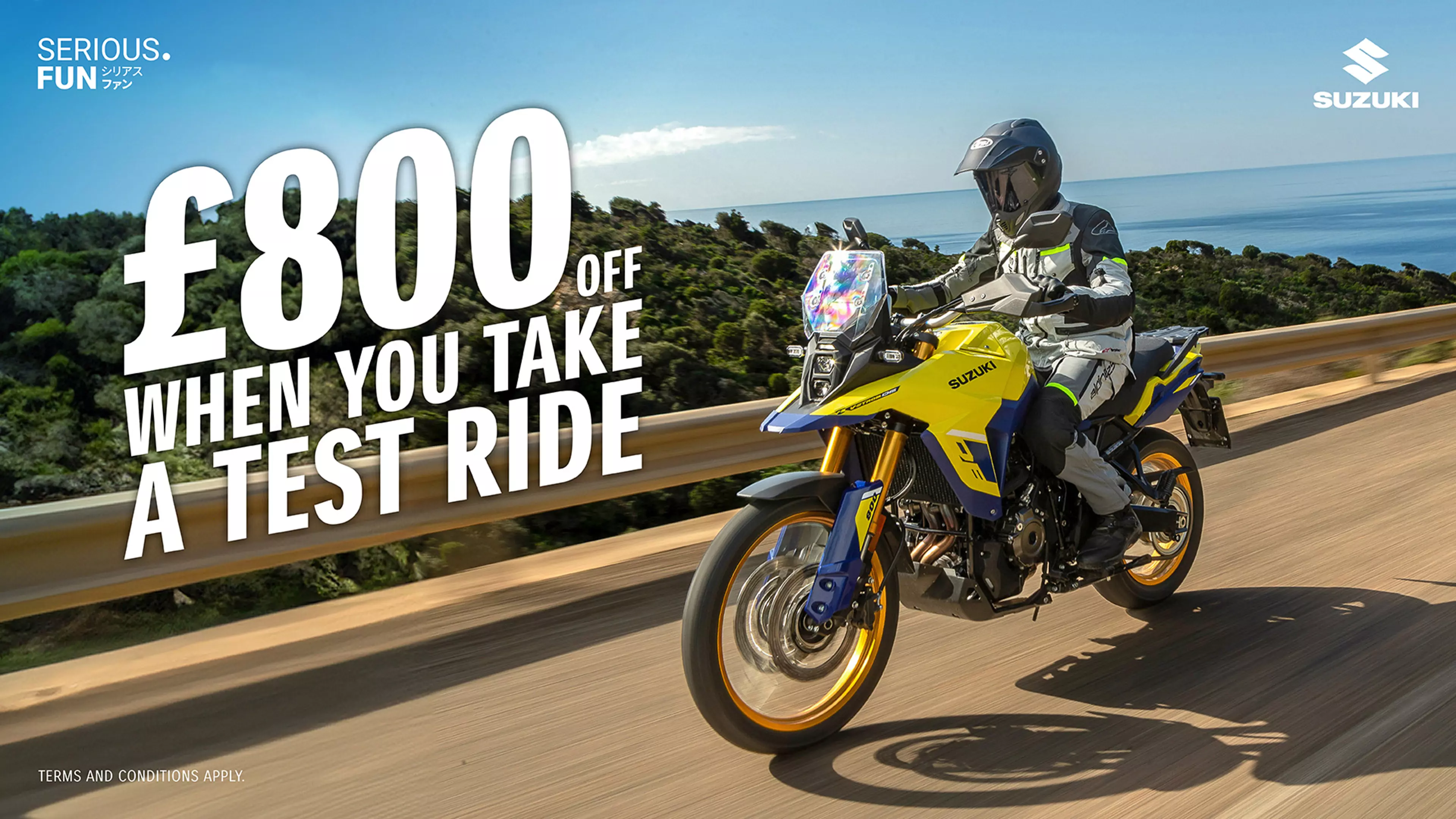 A rider enjoying a scenic coastal highway ride on the Suzuki V-Strom 800DE, set against a backdrop of blue skies and ocean views - with promotional messaging. 