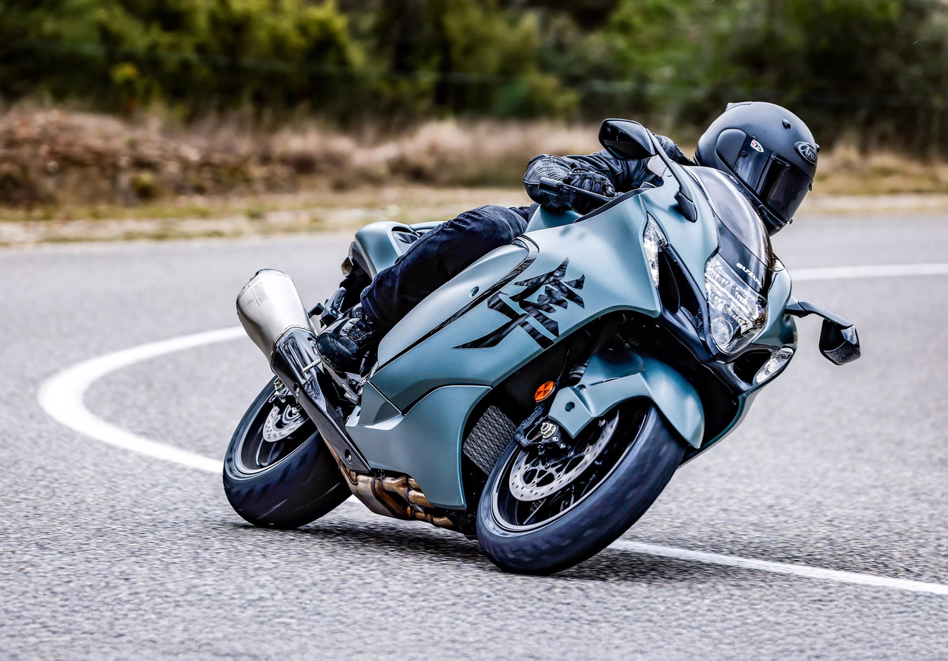 Suzuki Hayabusa leaning hard into a corner on a country road.