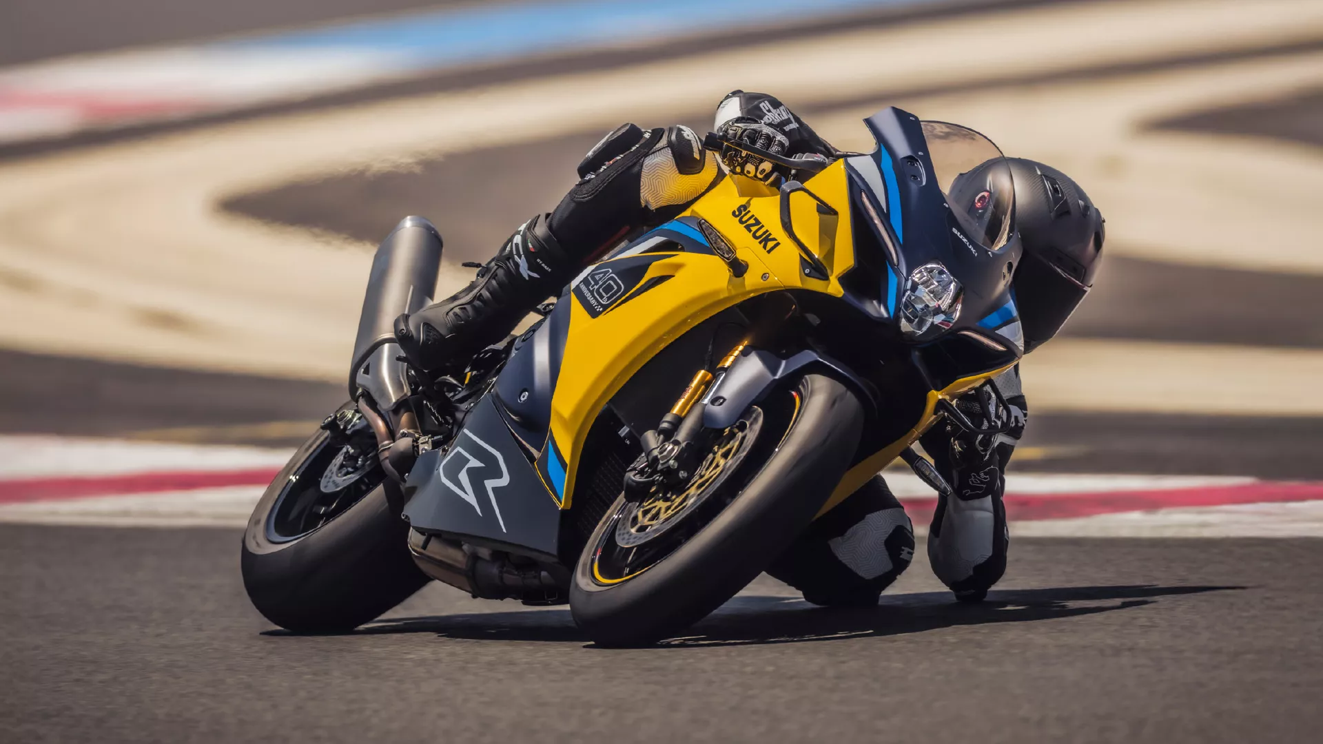 Suzuki GSX-R1000R yellow, with elbow down pushing round a corner on track