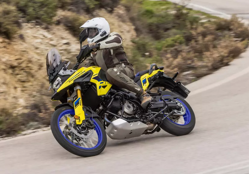 Suzuki V-Strom 1050DE leaning gently into a corner on a country road