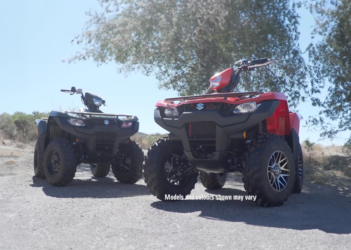 Two Suzuki KingQuads on a road