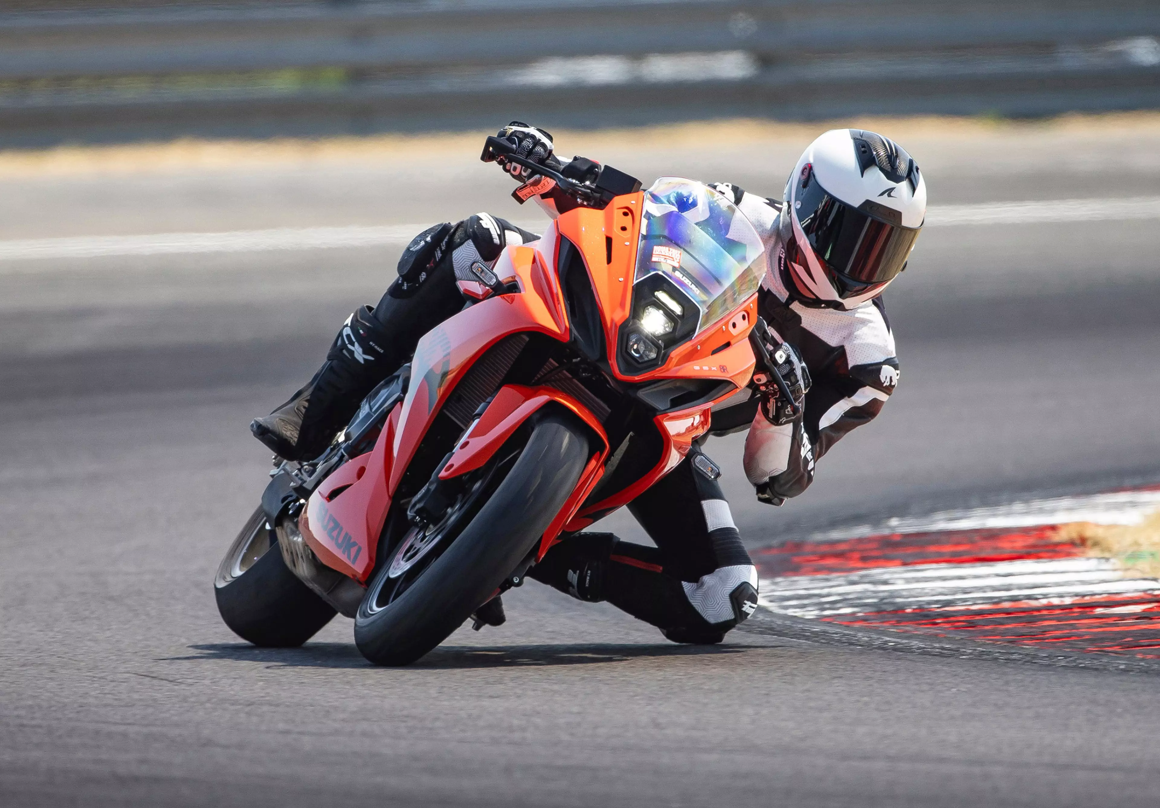 Suzuki GSX-8R leaning into a corner on track with knee down.