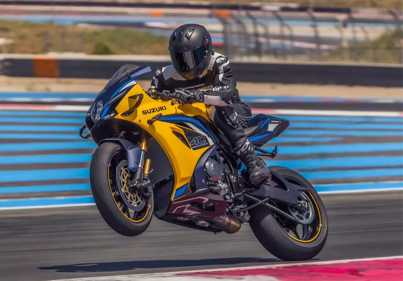 Suzuki GSX-R1000R pulling a controlled wheelie out of a corner