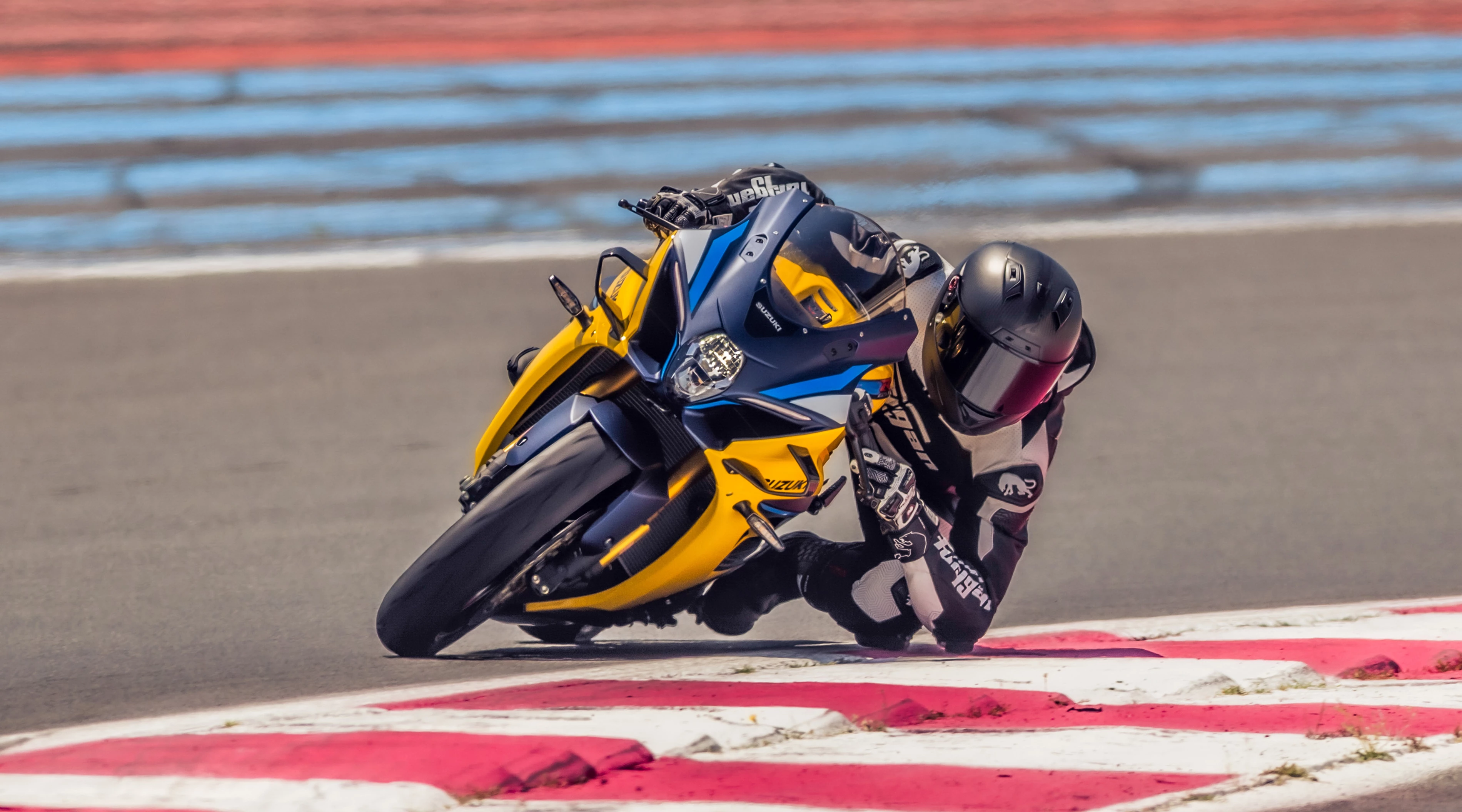 Suzuki GSX-R1000R leaning hard into a corner out on track.