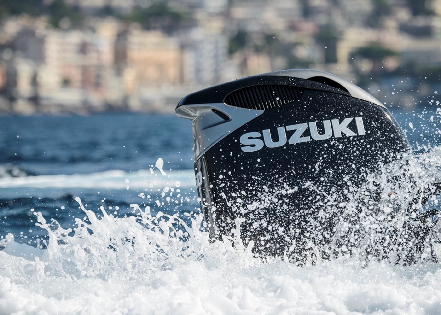 Suzuki outboard powering a boat at speed.