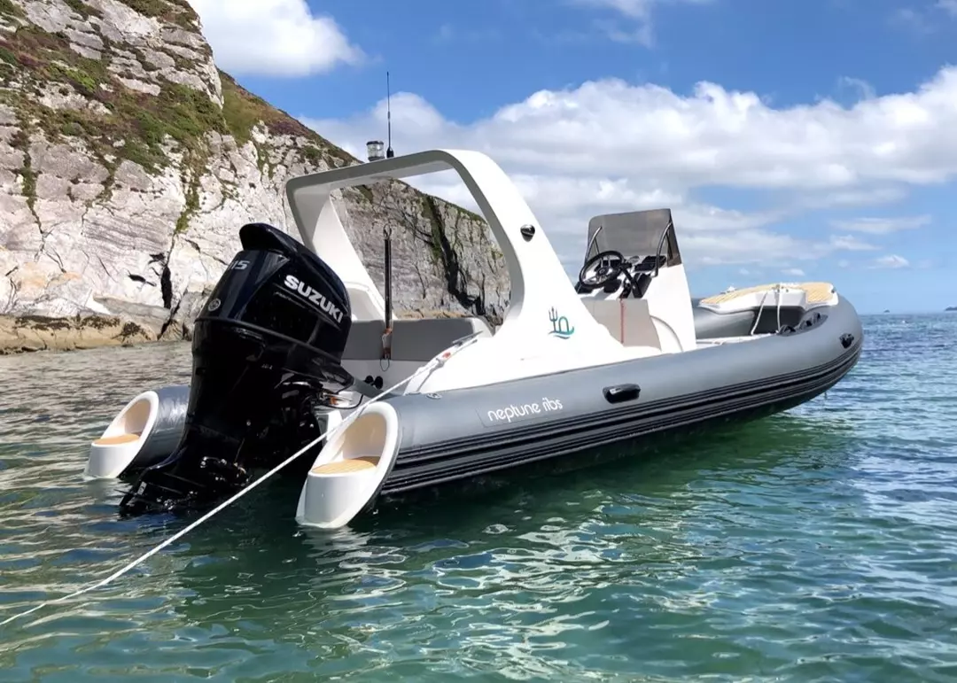 A rear view of a Neptune RIB at anchor powered by a Suzuki outboard