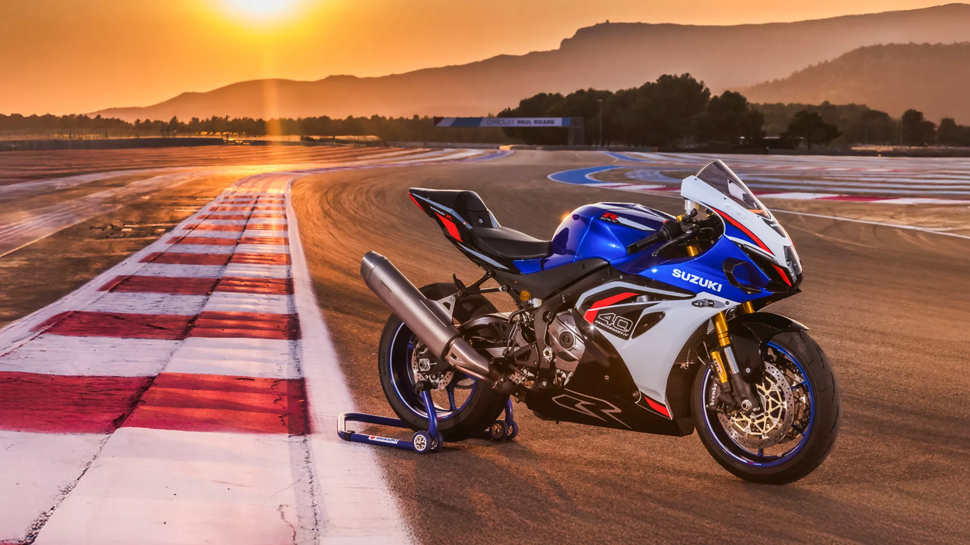 Suzuki GSX-R1000R blue, static on track with a sunset background