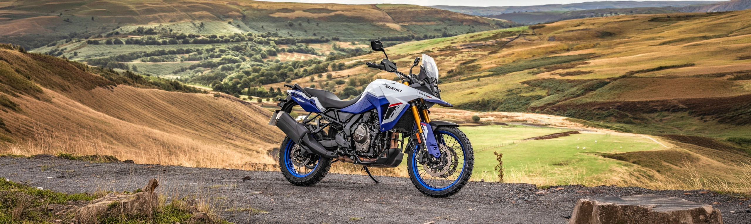 Suzuki V-Strom 800DE right hand side on on top a hill with a valley behind