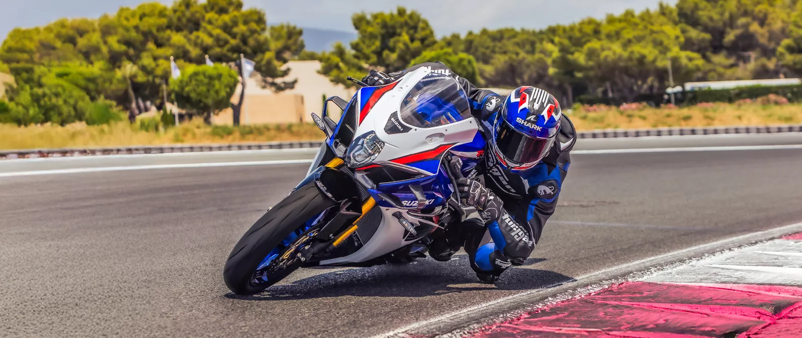 Suzuki GSX-R1000R leaning hard into a corner out on track.