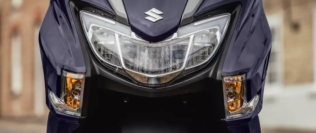 Suzuki Burgman Street 125EX close-up of the headlight design, emphasizing its modern styling and LED lighting features.