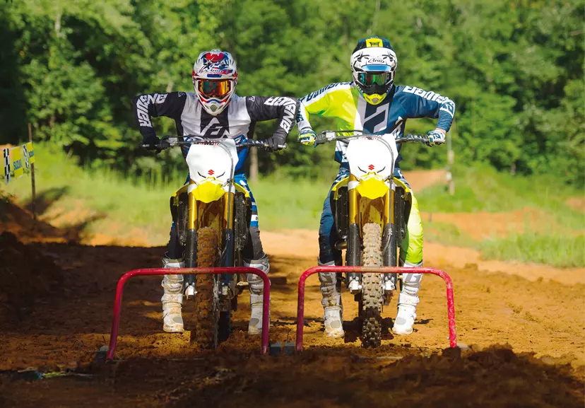 Suzuki RM-Z250 holeshot with another bike behind the start gate on a Motocross track