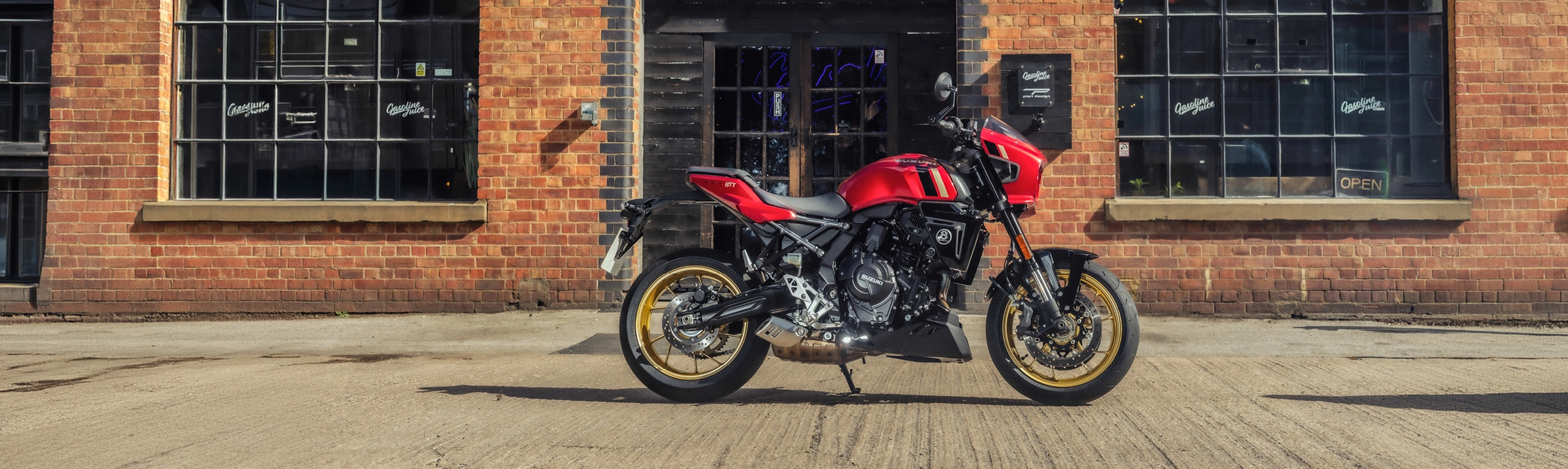 Suzuki GSX-8TT red, static right hand side in front of an old brick industrial building