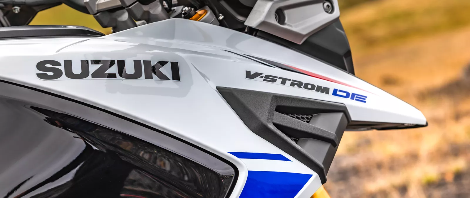Suzuki V-Strom 1050DE white right hand side close up of the V-Strom and Suzuki logos