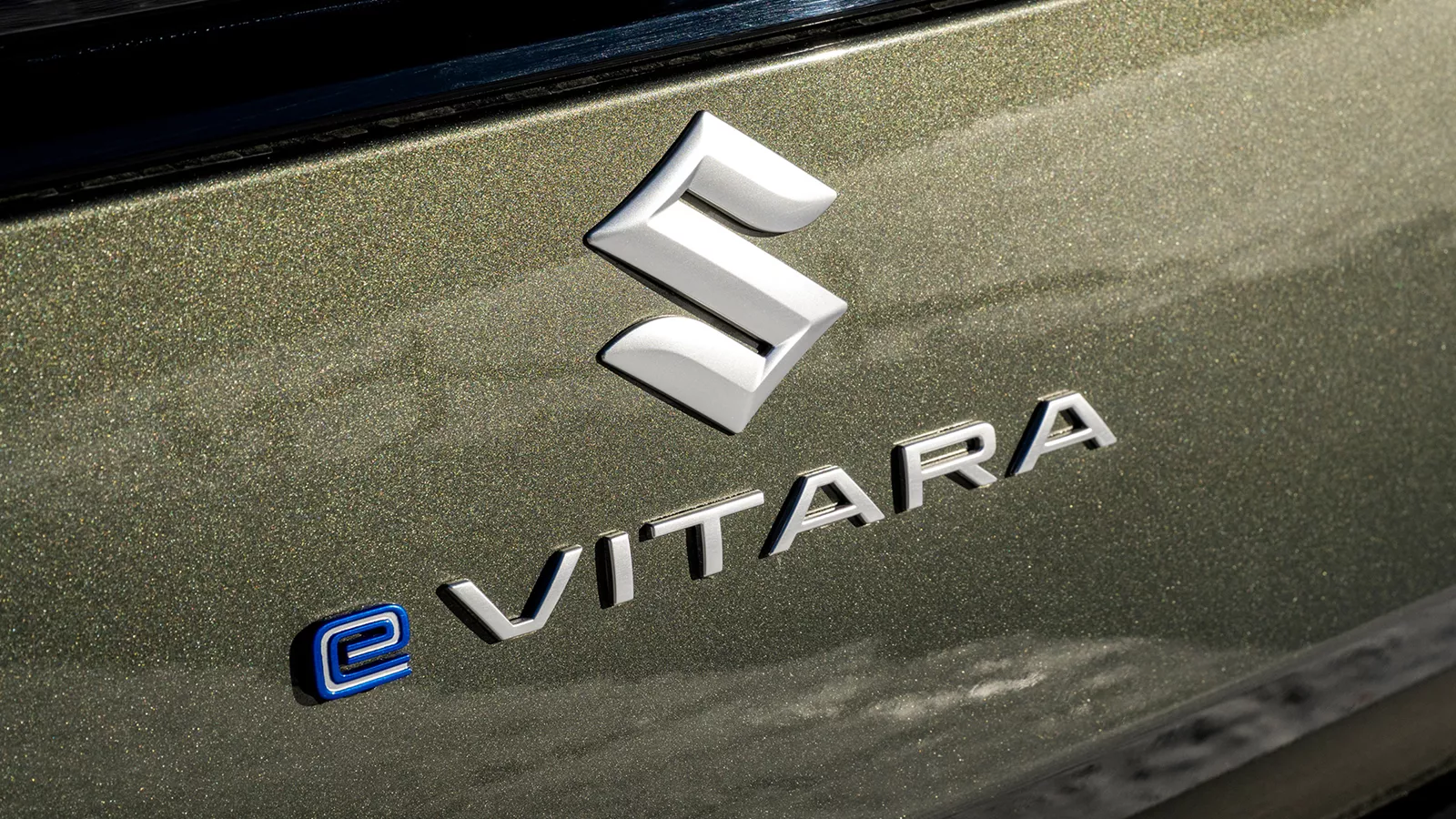 Close-up of the Suzuki e-Vitara rear badge with metallic paint finish