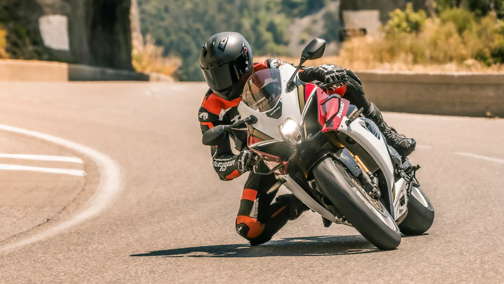 Suzuki GSX-R1000R red, leaning into a corner on a country road