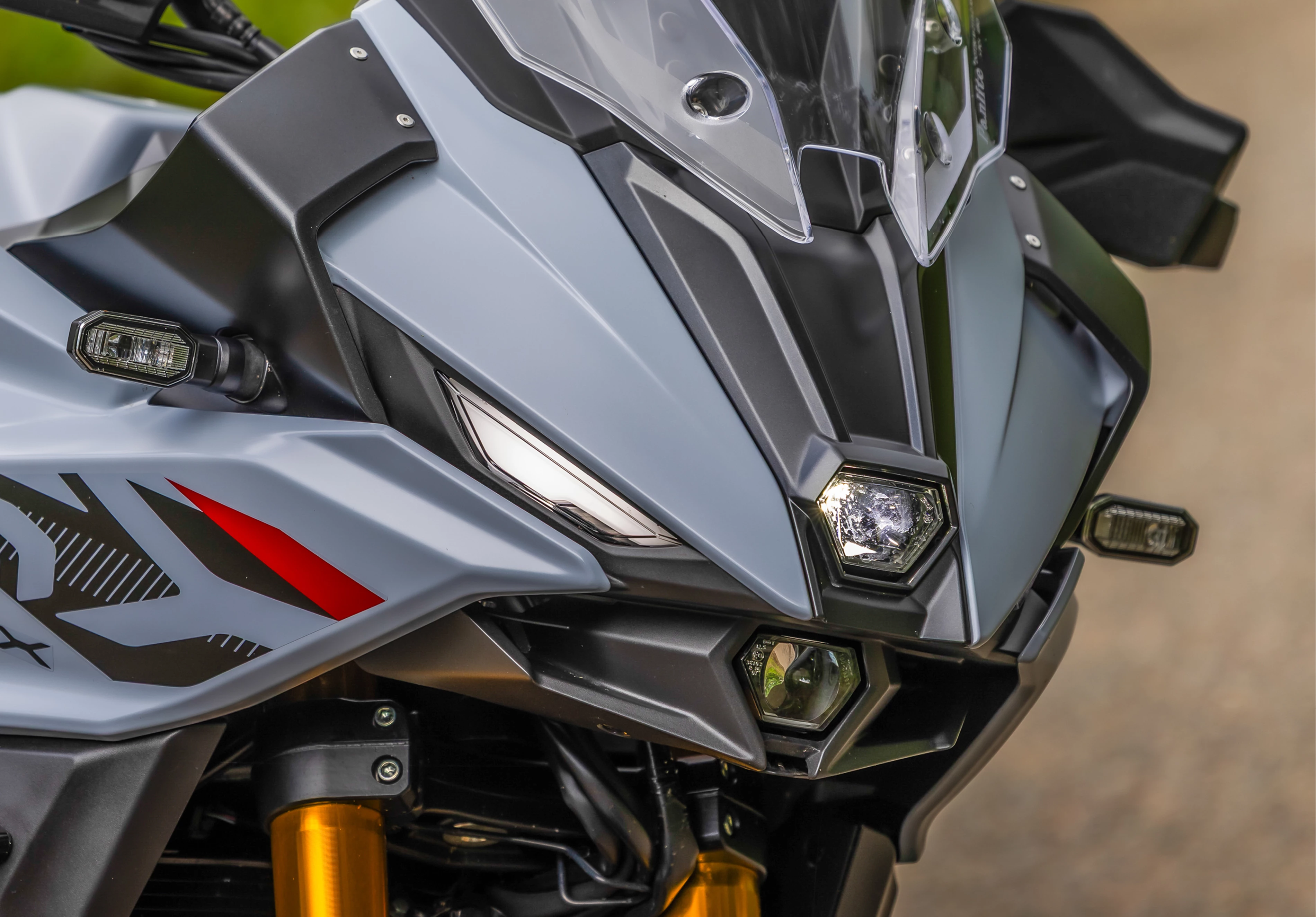 Suzuki GSX-S1000GX+ front end close-up showcasing headlights and winglets.