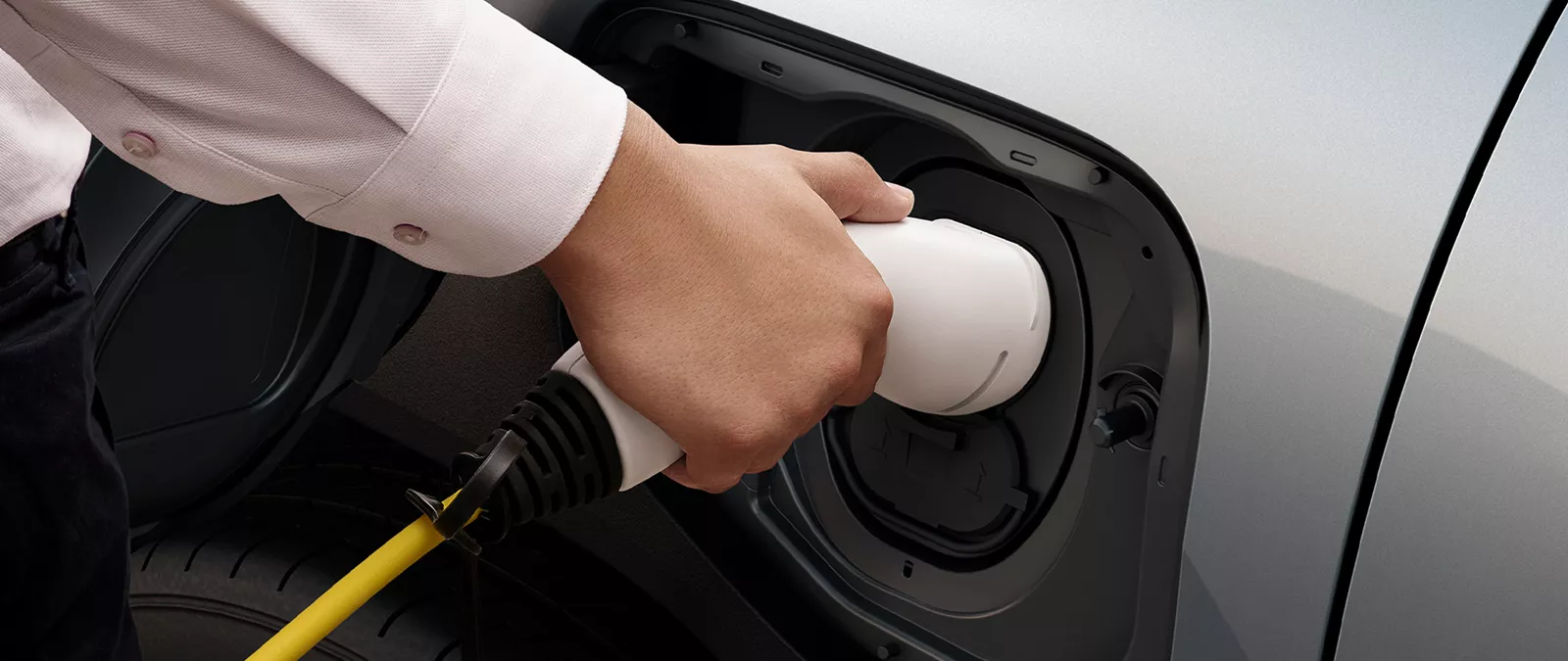 Close-up of a person plugging in a charging cable to the Suzuki e-Vitara electric vehicle