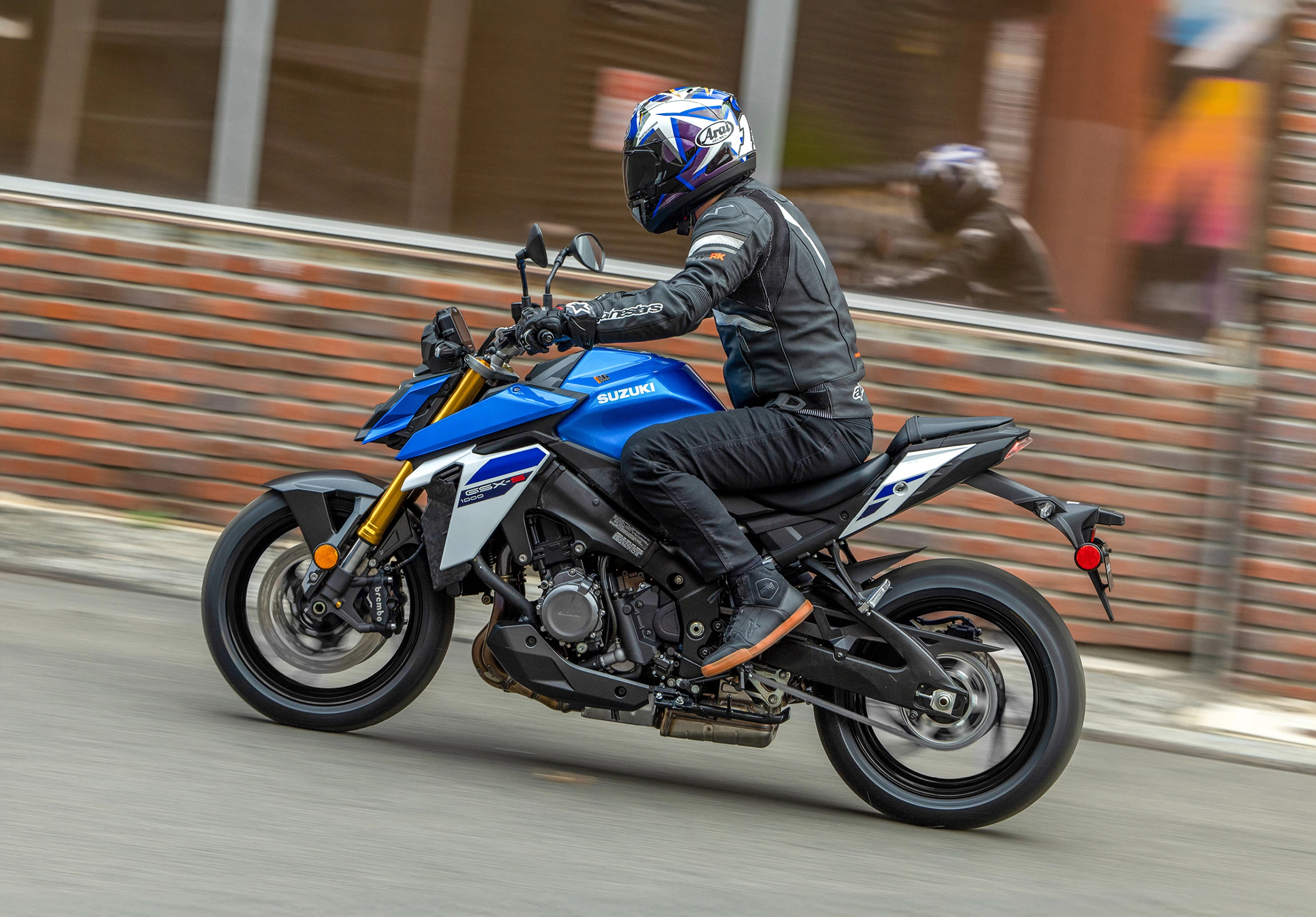 Suzuki GSX-S1000 riding along with a city background