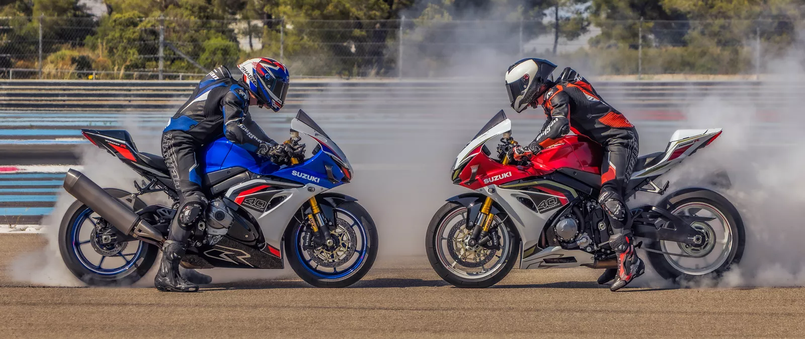 Suzuki GSX-R1000R red and blue side on, nose to nose, performing burnouts on track