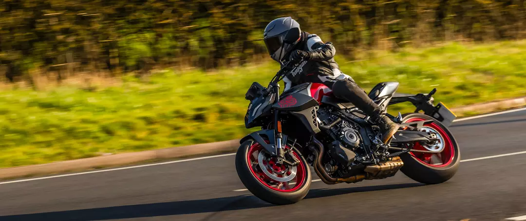 Suzuki GSX-8S red and black heading into a corner on a country road