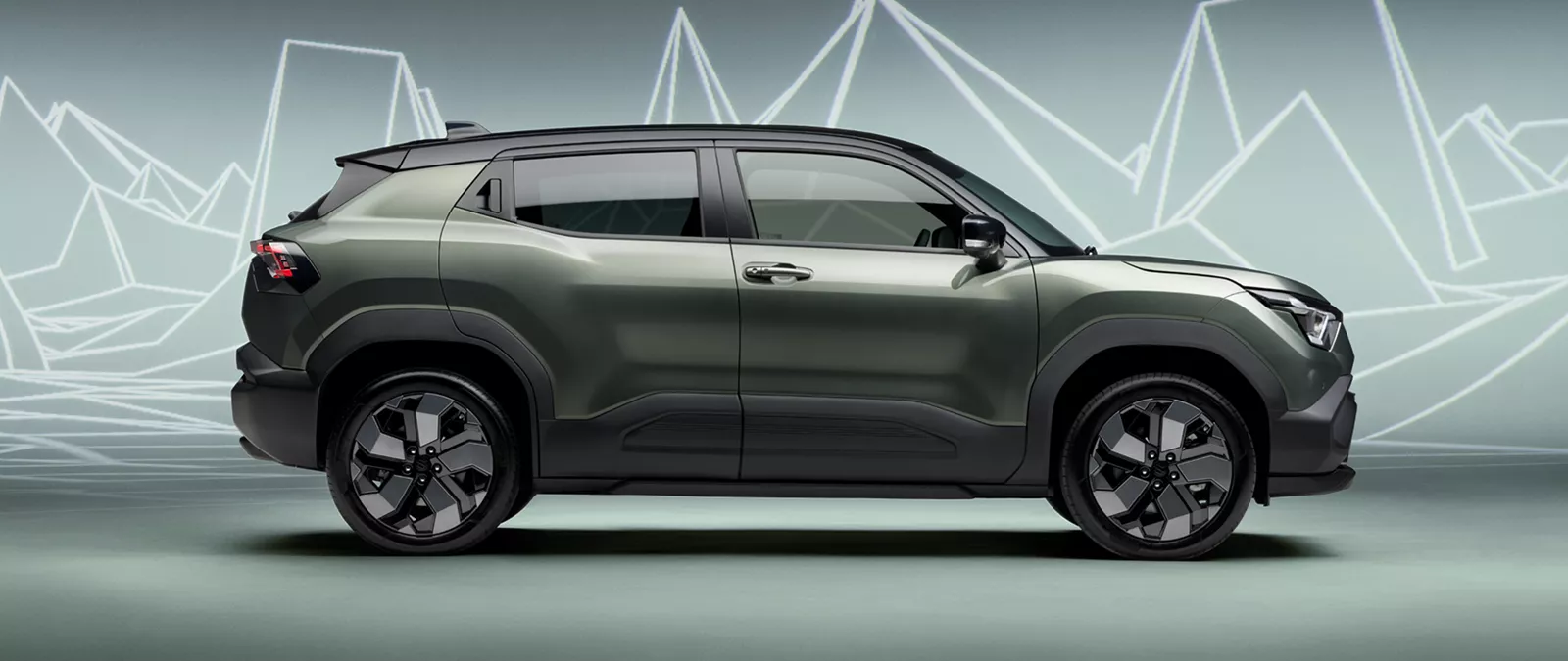 Side profile of the Suzuki e Vitara in Land Breeze Green Pearl Metallic, highlighting its sculpted SUV body
