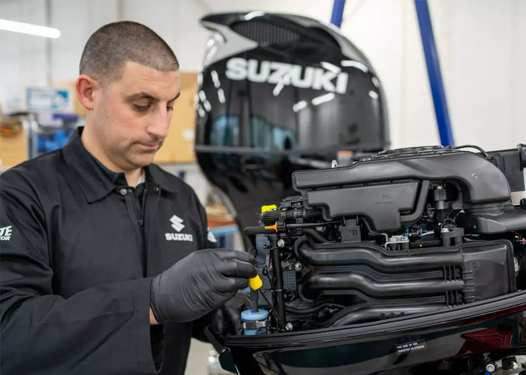 Suzuki engineer servicing a Suzuki outboard motor