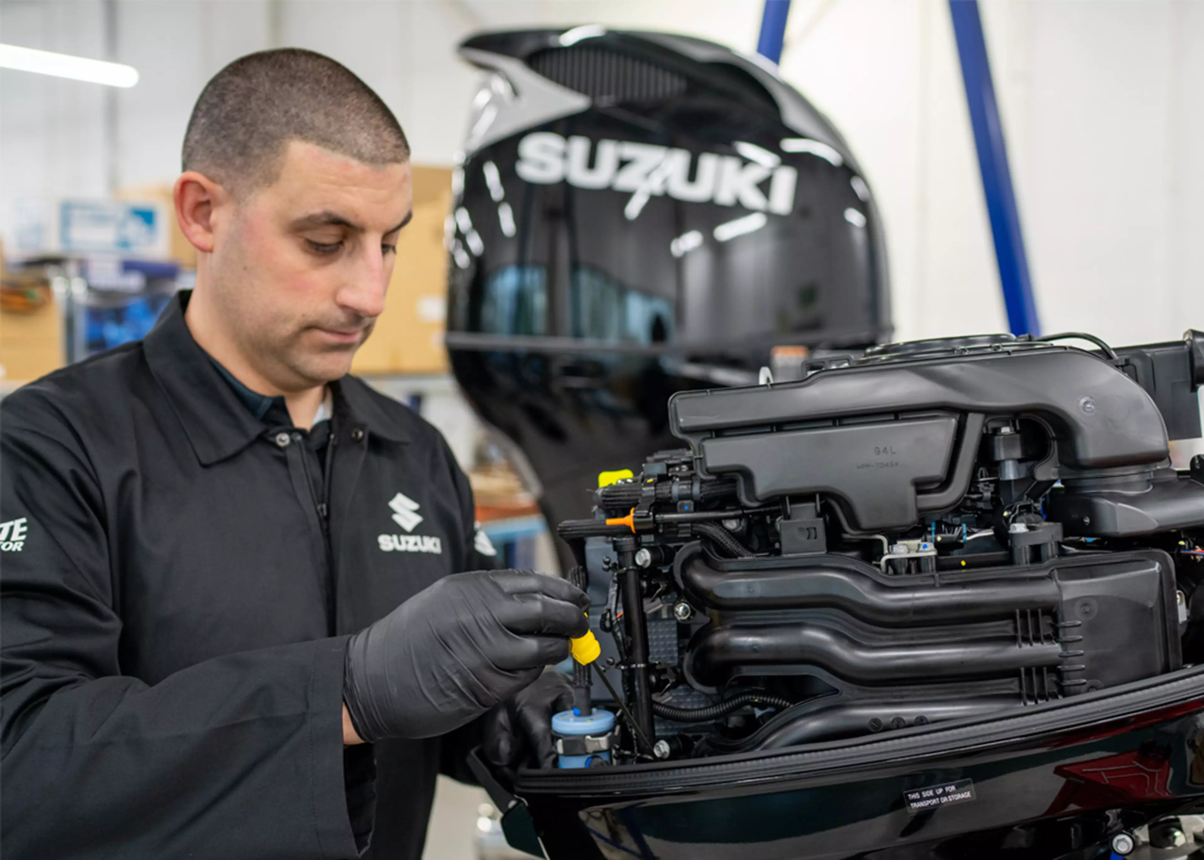 Suzuki engineer servicing a Suzuki outboard motor