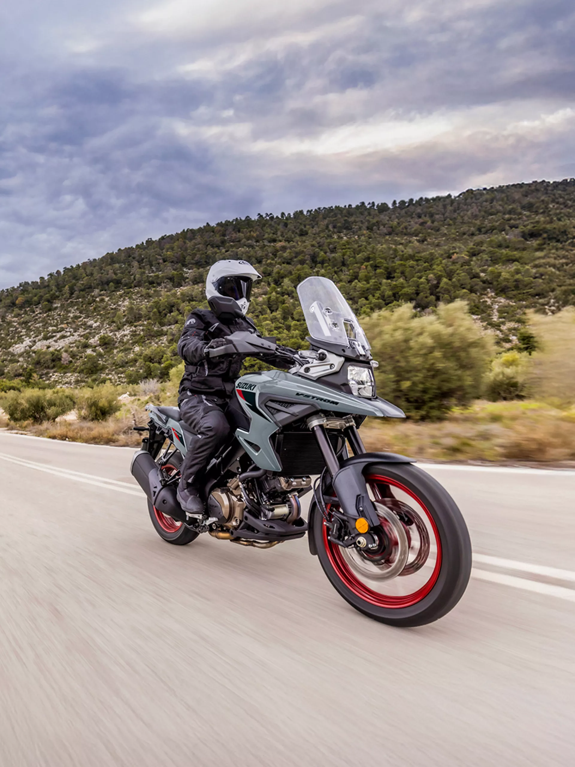Suzuki V-Strom 1050RE blasting along a mountain pass.