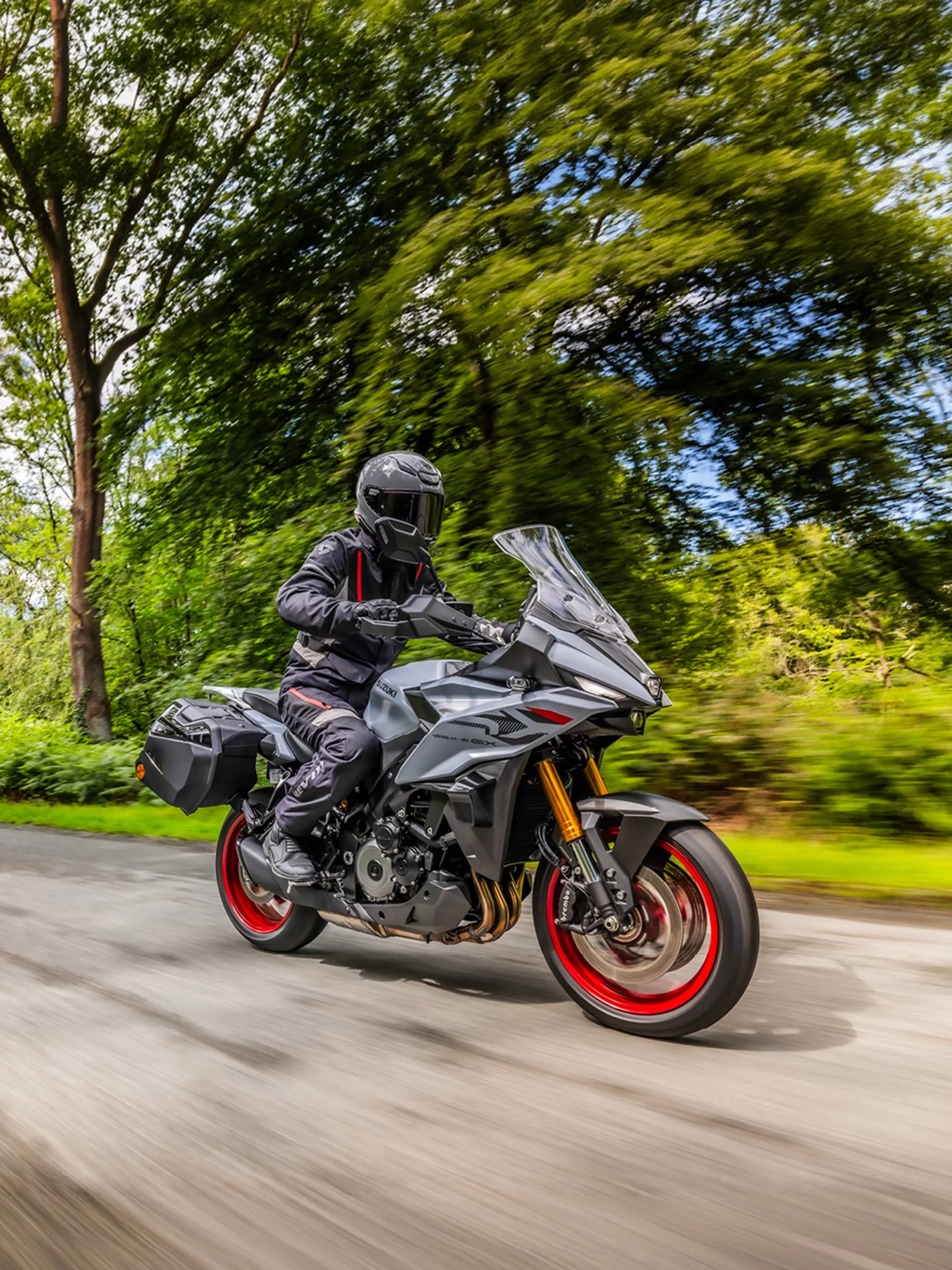 Suzuki GSX-S1000GX+ on a tree lined road
