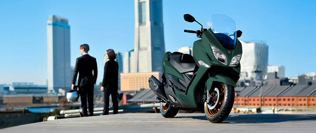 Suzuki Burgman 400 static front three quarters with city background.