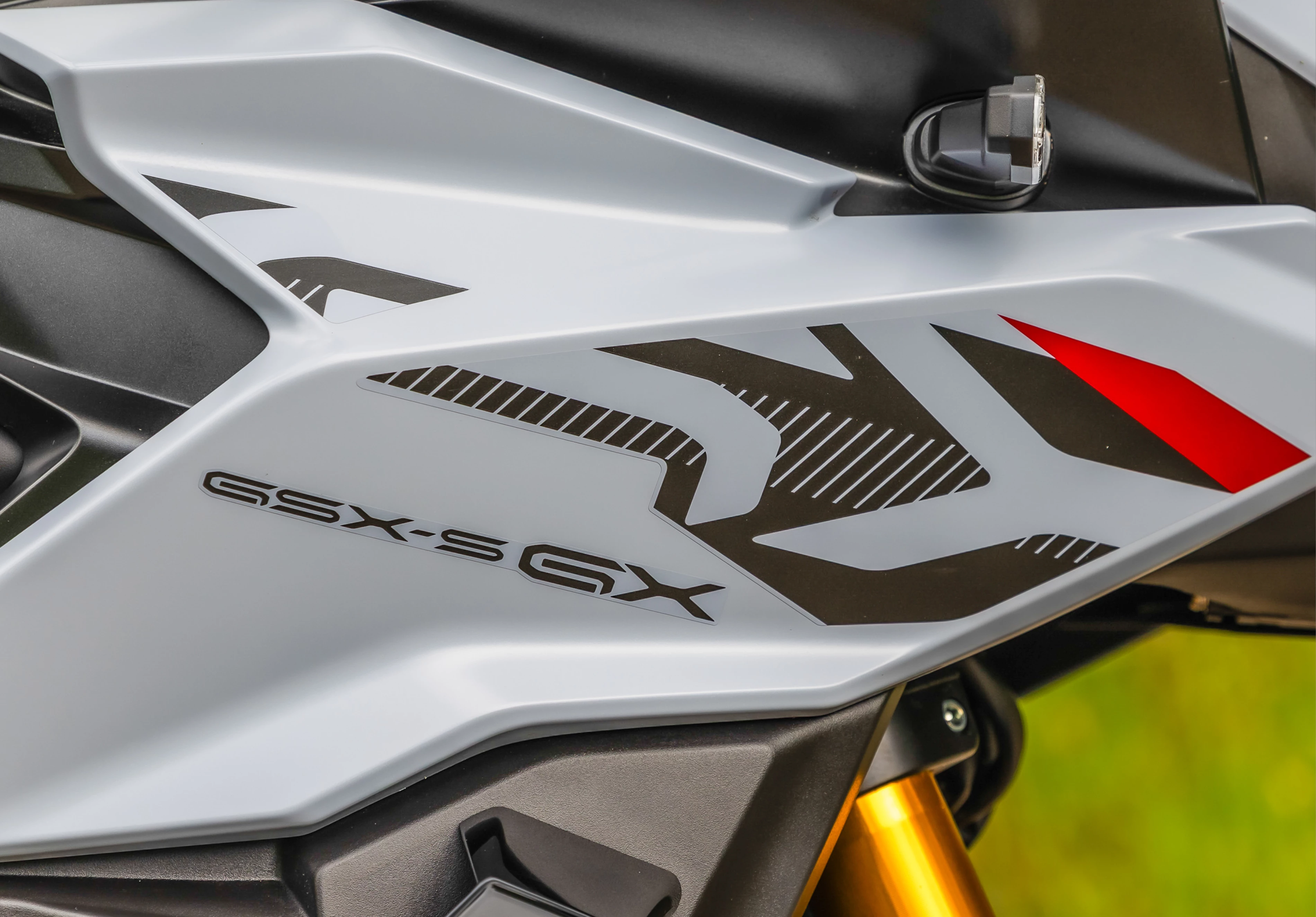 Suzuki GSX-S1000GX+ close up of the model logo on the front right of the fairing.