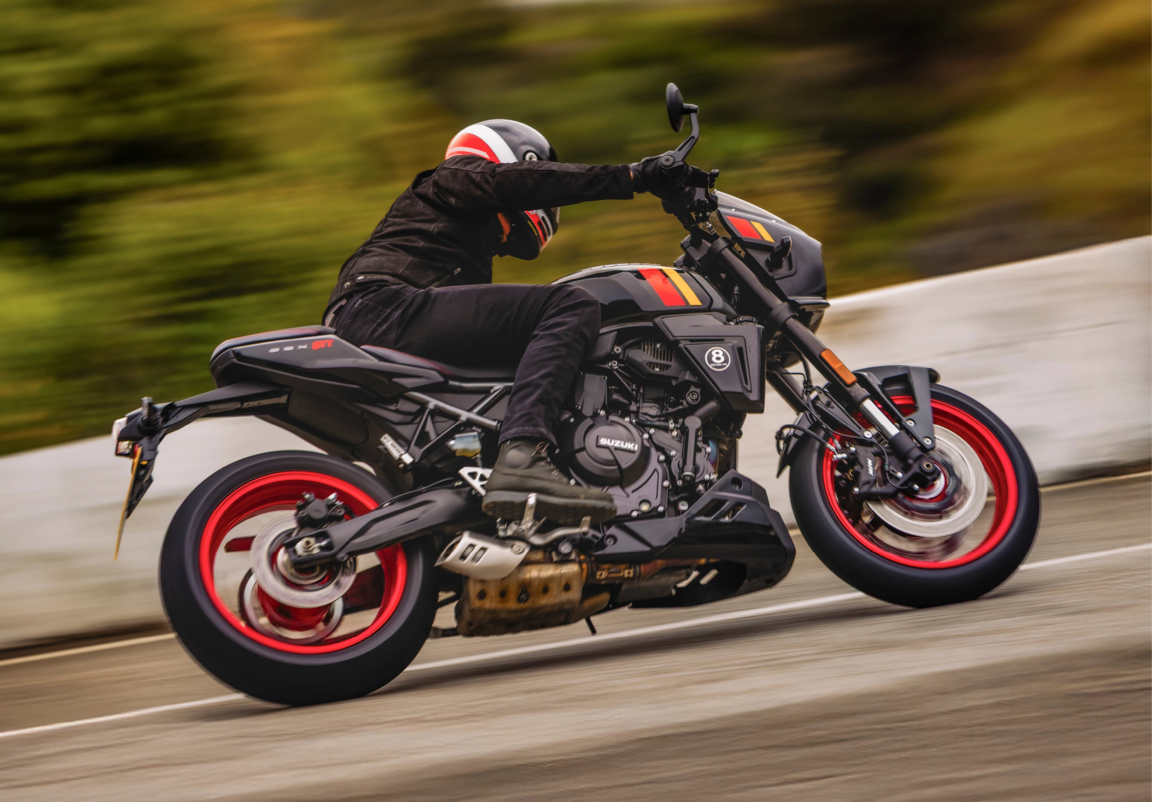 Suzuki GSX-8TT leaning hard into a corner on a country road.