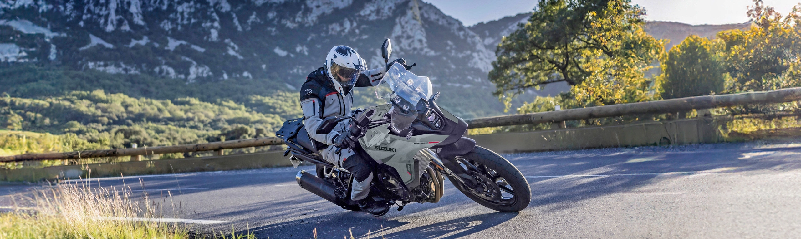 Suzuki V-Strom 800RE grey pushing hard into a corner on a mountain pass