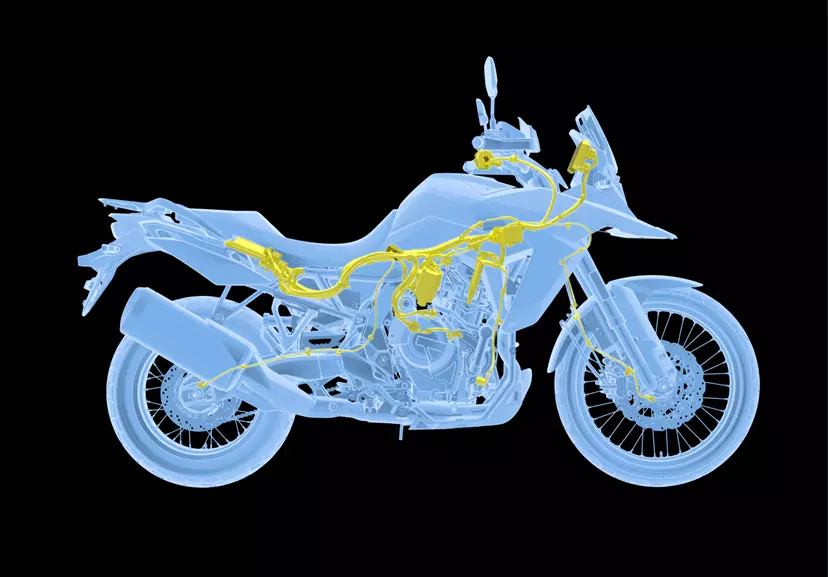 A rider leaning into a turn on the Suzuki V-Strom 800DE along a paved road, demonstrating the bike’s nimble handling.