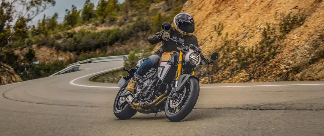Suzuki GSX-8T leaning hard into a corner on a mountain pass.