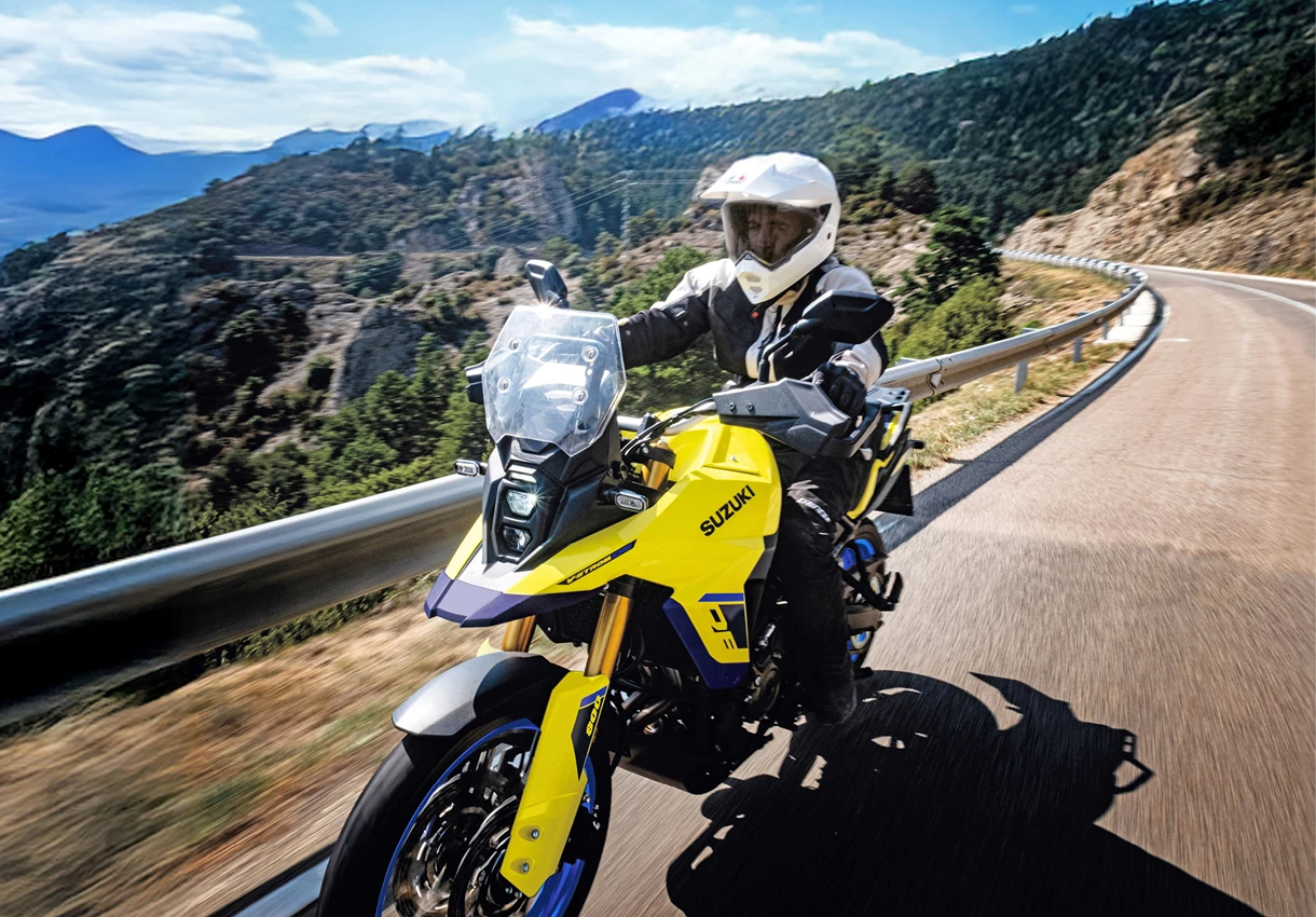 A rider powering through a rugged dirt trail on the Suzuki V-Strom 800DE, kicking up dust and showcasing its off-road capabilities.